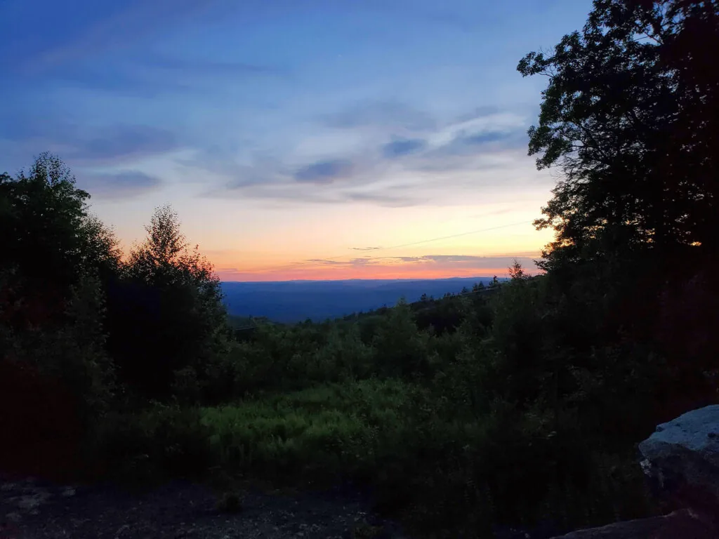 Sunset over wooded hills, photographed during Survival
